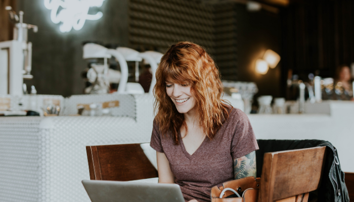 Fille dans un café qui magasine en ligne